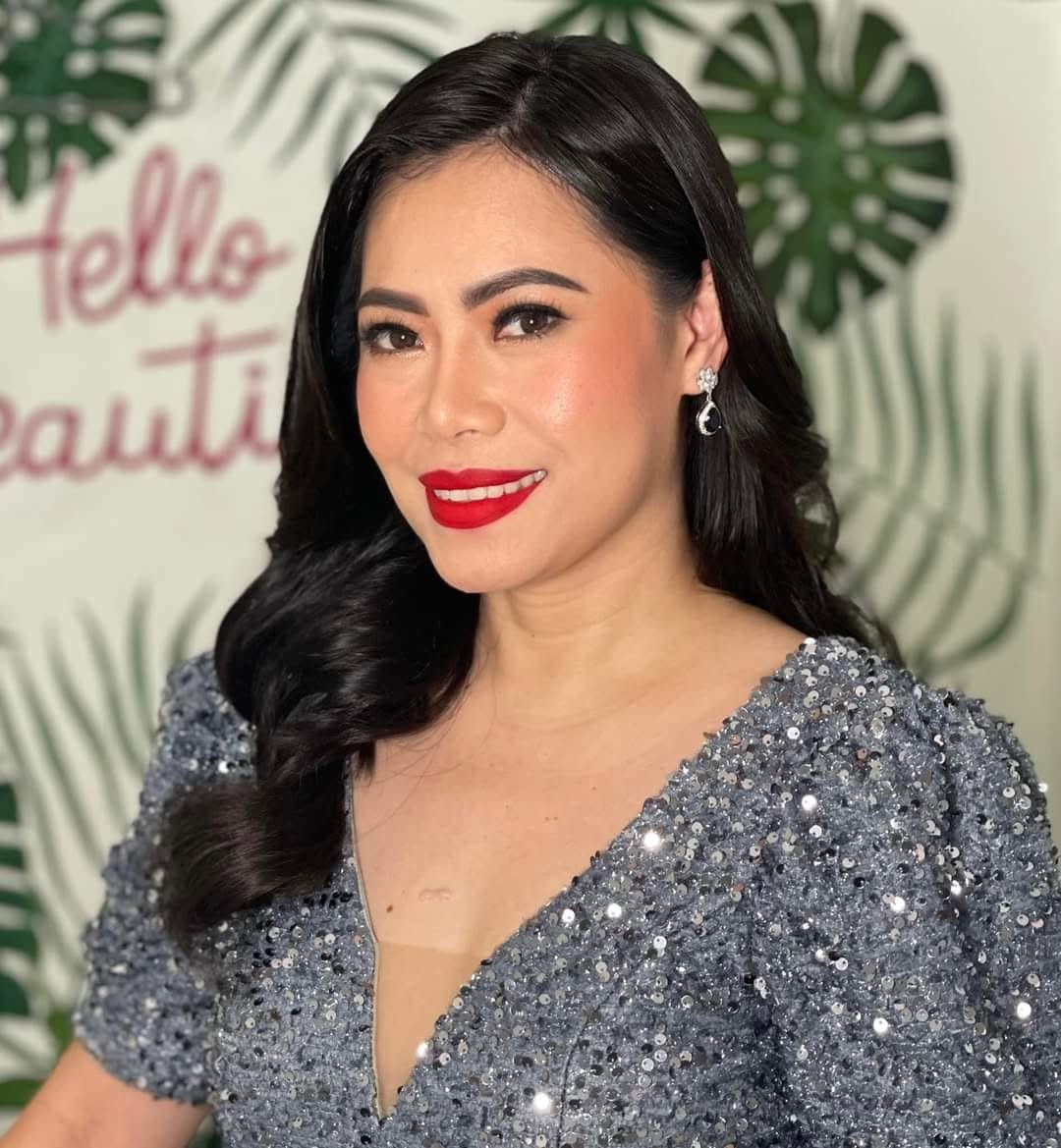 The founder of Charm Advance Aesthetic Center at the studio's Hello Beautiful wall